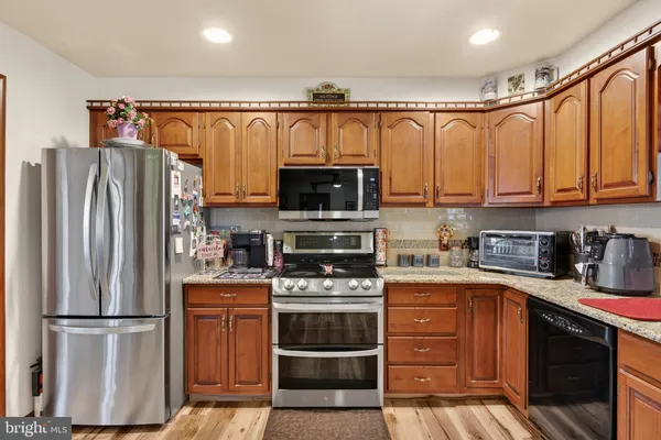 a kitchen with granite countertop a refrigerator stove and microwave
