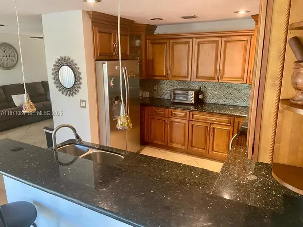 a kitchen with granite countertop a sink stainless steel appliances and cabinets