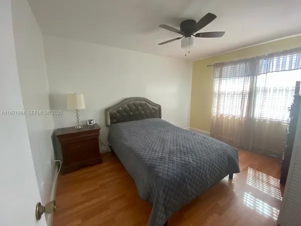 a bedroom with a bed and a lamp on dresser