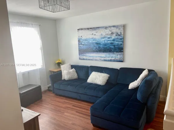 a living room with furniture and a painting on the wall