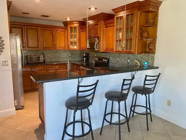 a kitchen with stainless steel appliances granite countertop a sink and a refrigerator