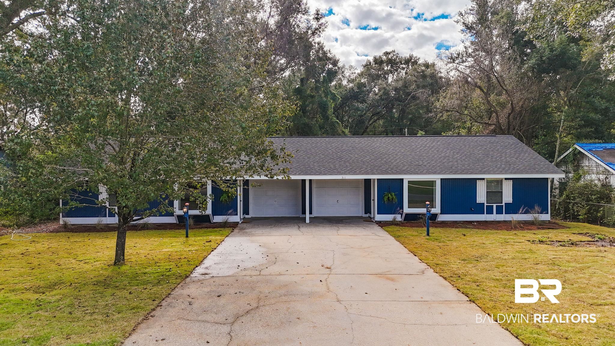 309 West Roosevelt Avenue Foley, AL 36535 - Photo 1 of 60 View of front facade featuring a garage and a front lawn