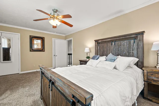 a bed room with a bed and a ceiling fan