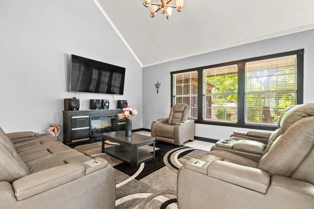 a living room with furniture a flat screen tv and a large window