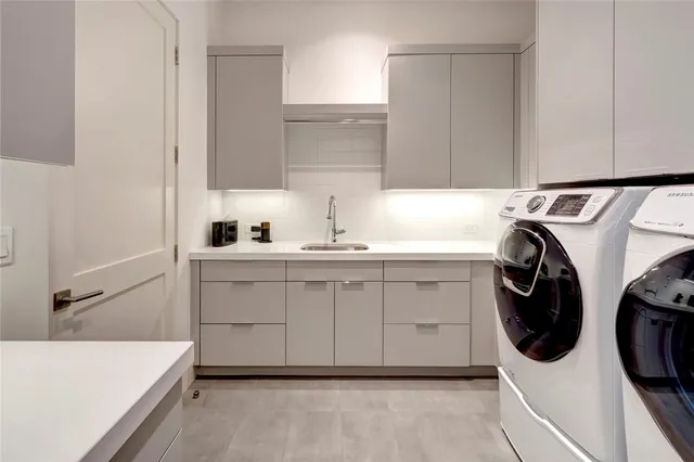 a utility room with sink dryer and washer