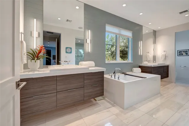 a bathroom with a sink mirror and a bathtub