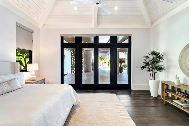 a bedroom with a large bed and a potted plant