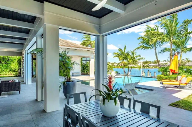 a view of a patio with table and chairs potted plants and a large tree