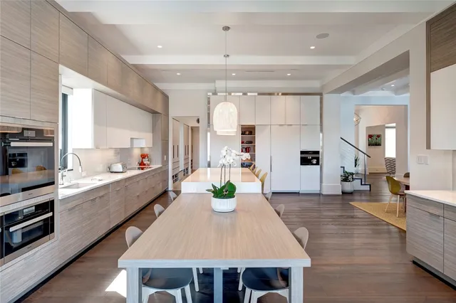 a large kitchen with kitchen island a large counter space dining table and stainless steel appliances