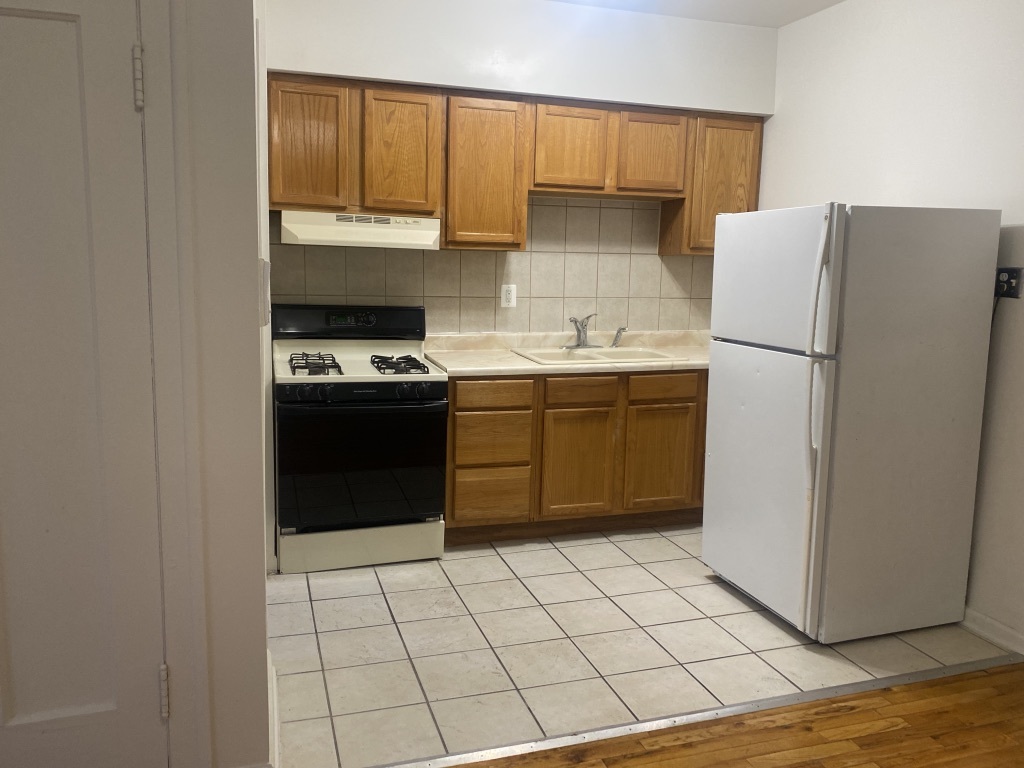 3045 West 63rd Street, Unit 201 Chicago, IL 60629 - Photo 4 of 8 a kitchen with a stove a sink and a refrigerator