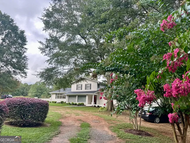 a front view of a house with a yard and fountain
