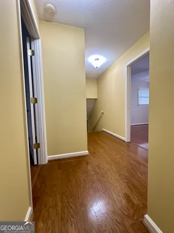 an empty room with wooden floor and entrance