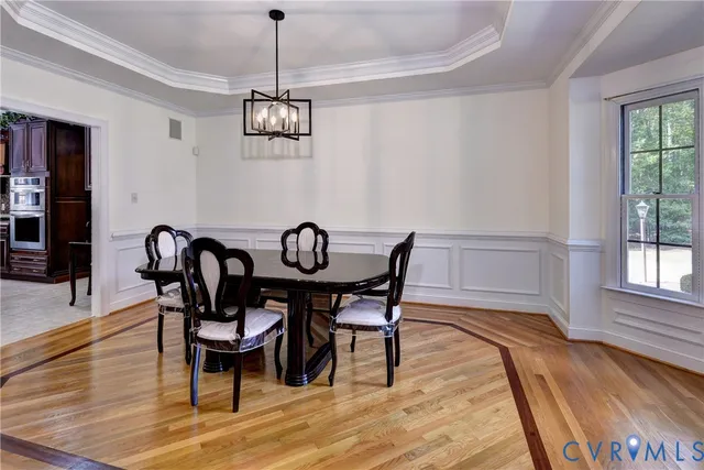 a kitchen with stainless steel appliances kitchen island granite countertop a refrigerator a stove a sink with a dining table and chairs