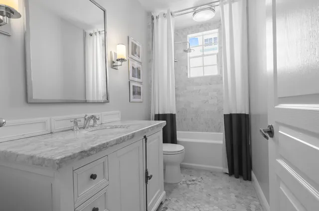 a bathroom with a granite countertop sink toilet and shower