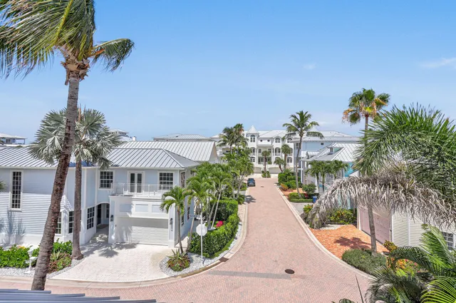 a view of a white house with a yard and potted plants