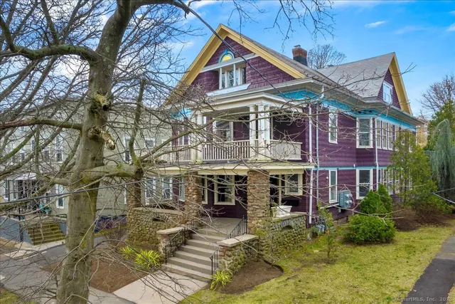 a view of a brick house with large windows and a small yard