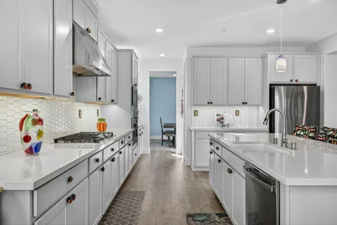 a kitchen with stainless steel appliances granite countertop a sink stove and refrigerator