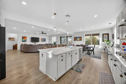 a kitchen with stainless steel appliances a stove a sink a refrigerator and cabinets