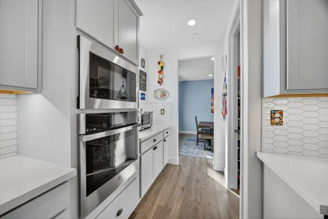 a kitchen with stainless steel appliances a table and chairs in it