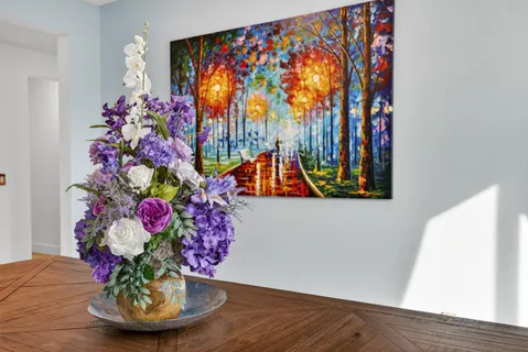 a vase of flowers sitting on a table with a potted plant