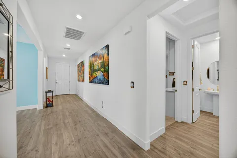 a view of a hallway with wooden floor and closet