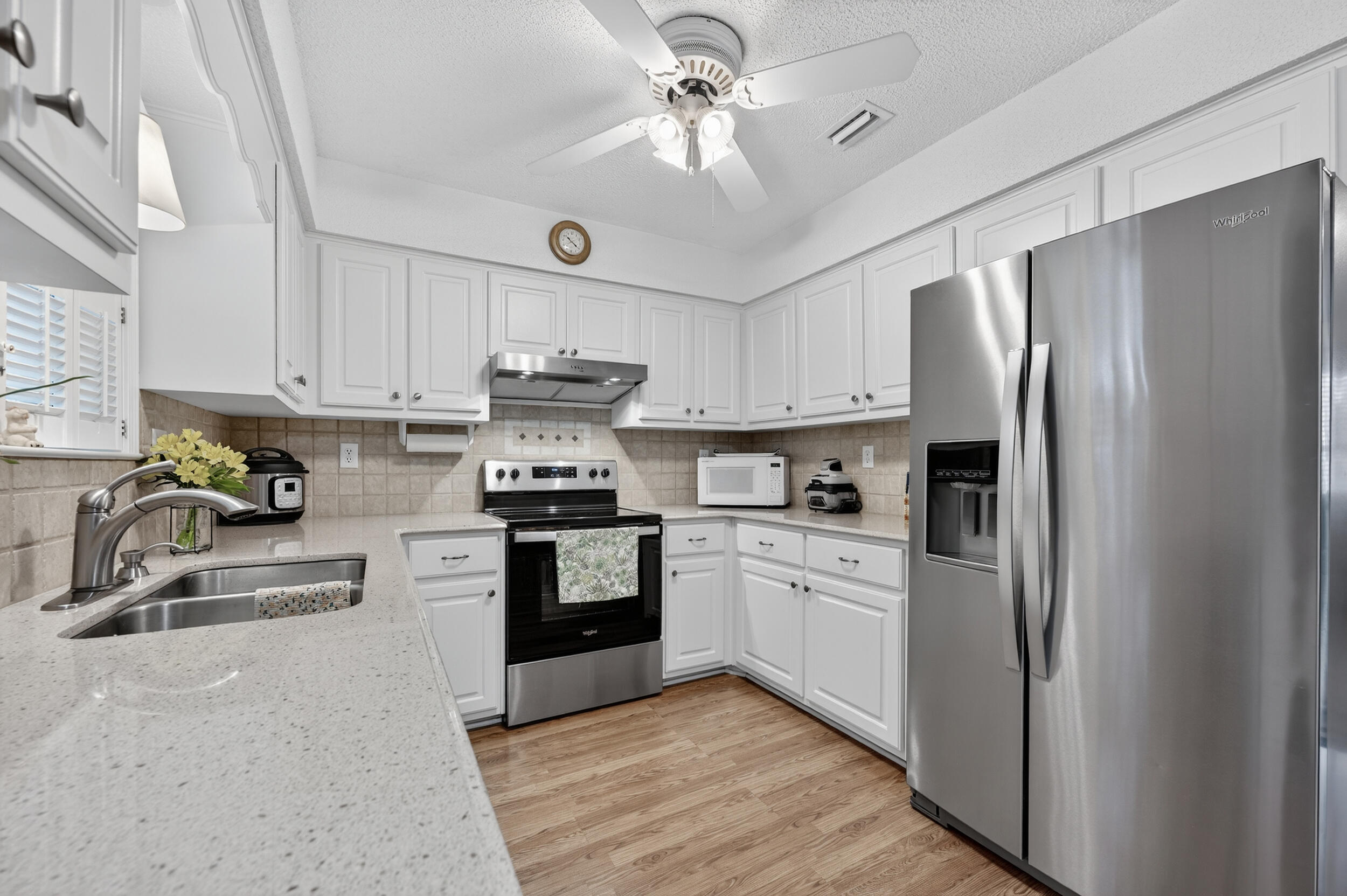 105 Cedar Point Road Crestview, FL 32539 - Photo 29 of 53 a kitchen with stainless steel appliances granite countertop a refrigerator a stove a sink and dishwasher with white cabinets