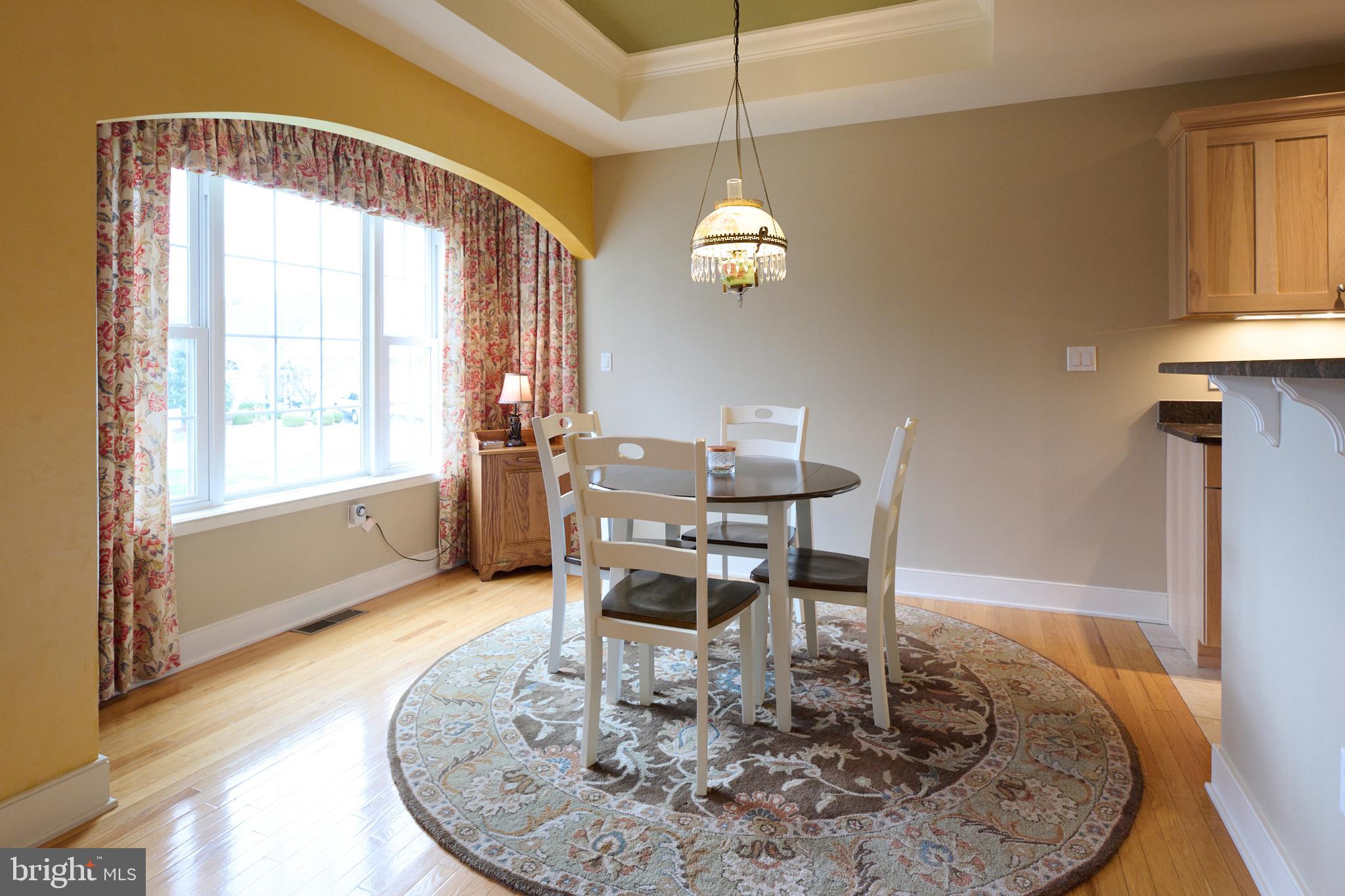 3296 Shellers Bend, Unit 144 State College, PA 16801 - Photo 12 of 48 a dining room with wooden floor a chandelier a wooden table and chairs