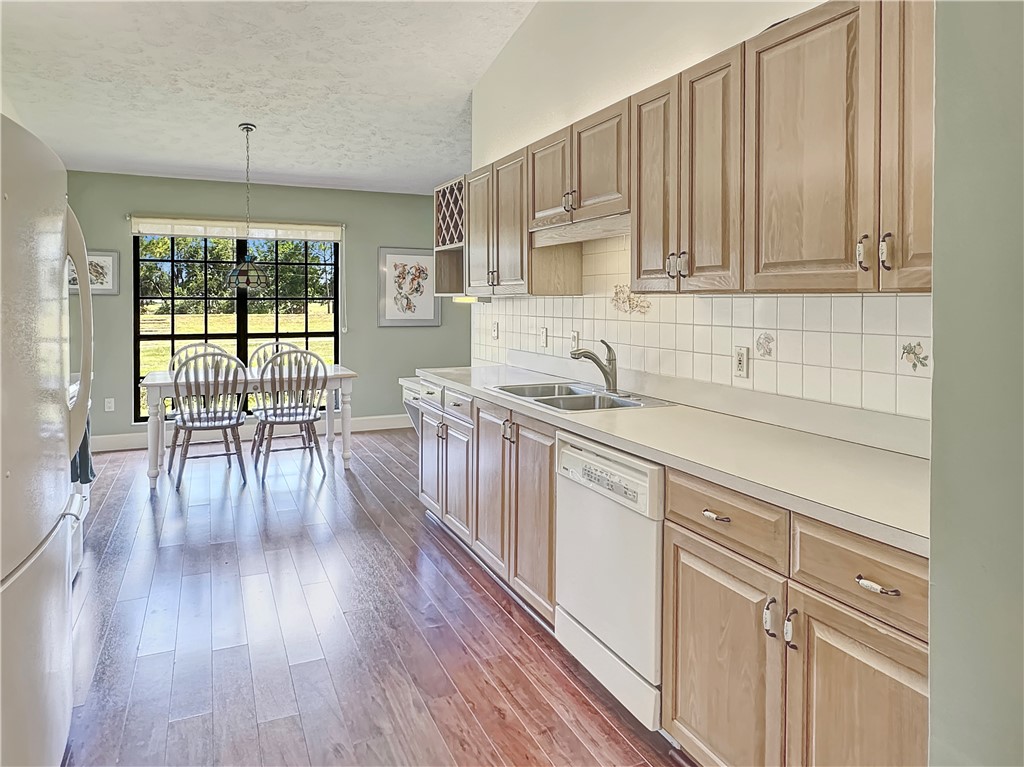 5408 Eagle Drive Fort Pierce, FL 34951 - Photo 4 of 35 a kitchen with stainless steel appliances granite countertop wooden floors a stove and white cabinets