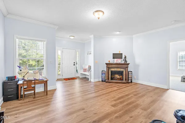 a view of a livingroom with furniture a fireplace and wooden floor