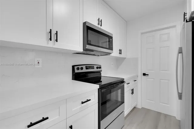 a kitchen with stainless steel appliances a stove microwave and sink