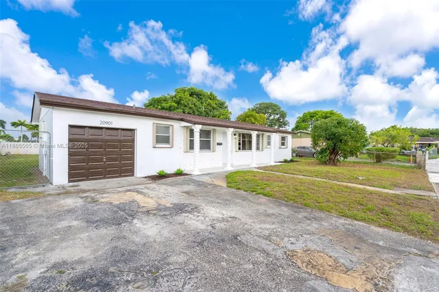 a view of a house with backyard and a tree