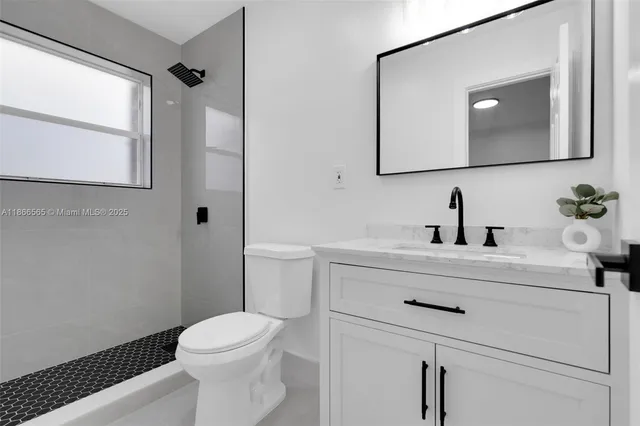a bathroom with a toilet a sink a vanity and mirror