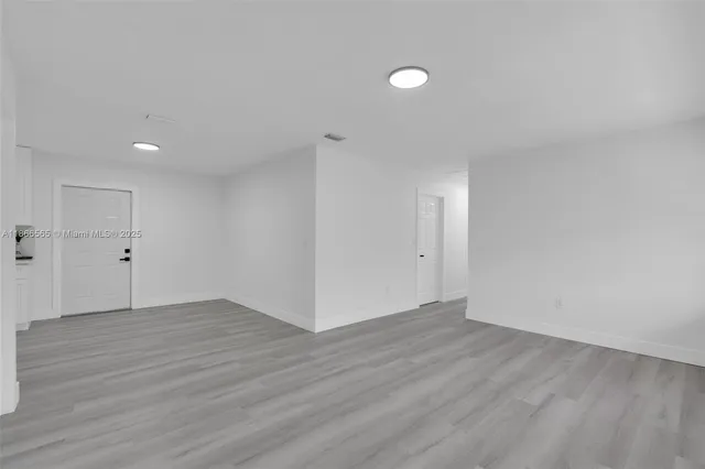 a view of an empty room with wooden floor