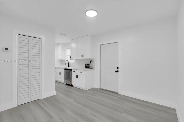 a kitchen with a refrigerator and white cabinets