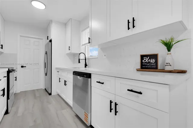 a hallway with white cabinets and wooden floor