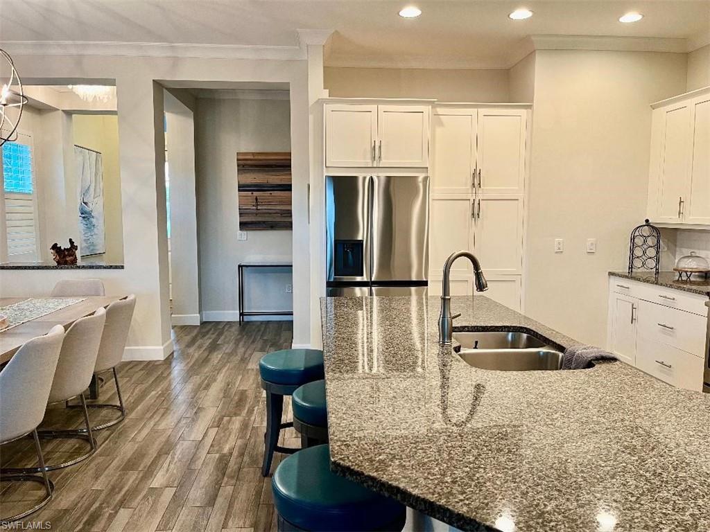 6907 Cay Court Naples, FL 34113 - Photo 4 of 15 a kitchen with kitchen island a counter top space appliances and cabinets