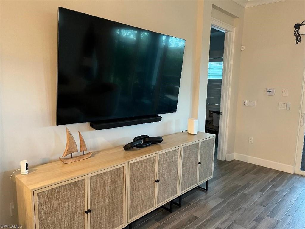 6907 Cay Court Naples, FL 34113 - Photo 8 of 15 a view of an empty room with wooden floor and a flat screen tv