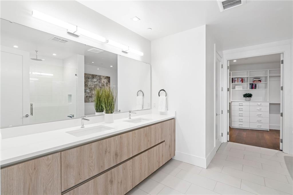 3107 Peachtree Road Northeast, Unit 1402 Atlanta, GA 30305 - Photo 40 of 72 a bathroom with a shower sink and mirror
