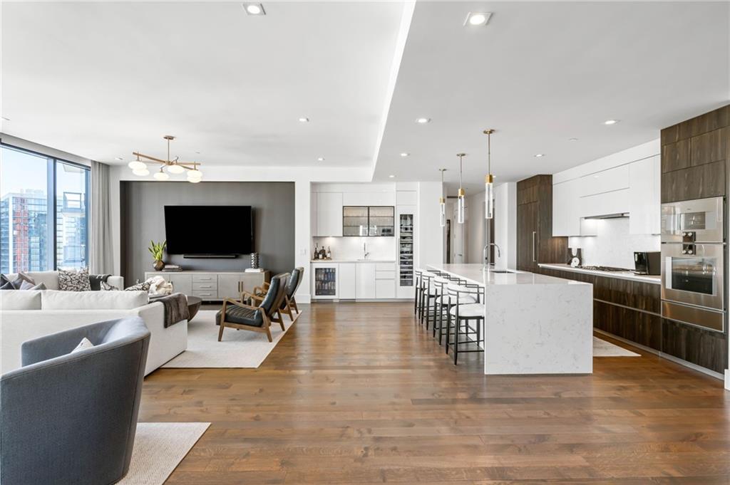 3107 Peachtree Road Northeast, Unit 1402 Atlanta, GA 30305 - Photo 4 of 72 a living room with furniture a flat screen tv and kitchen view