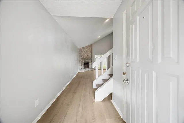 a view of a hallway with wooden floor and staircase