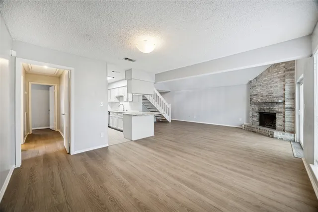 a view of empty room with wooden floor and fireplace