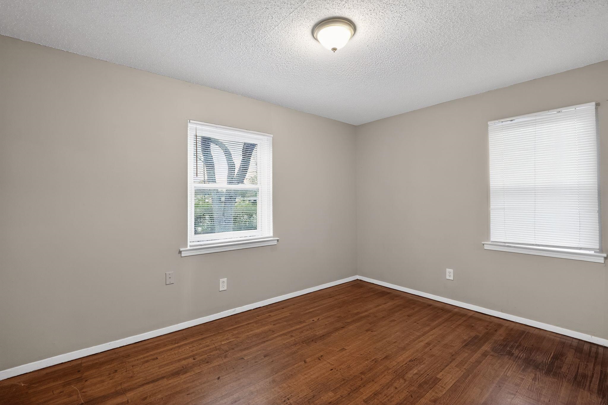 4314 Ford Road Memphis, TN 38109 - Photo 11 of 31 Empty room with a textured ceiling and dark wood finished floors