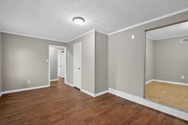a view of an empty room with wooden floor