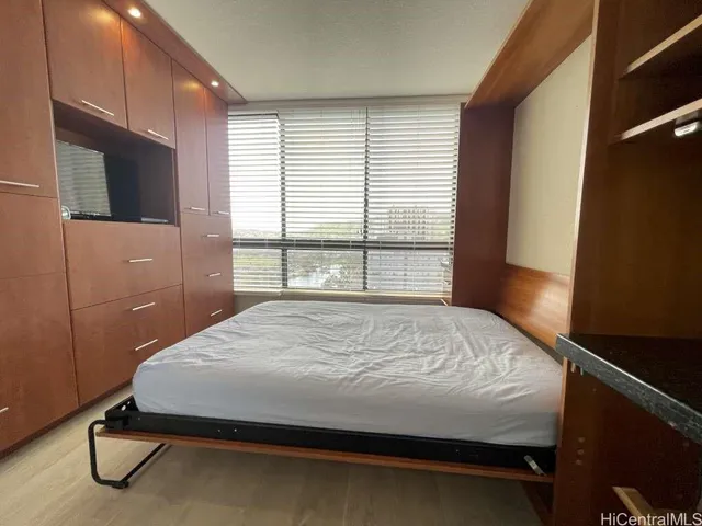 a bed sitting in a bedroom next to a window