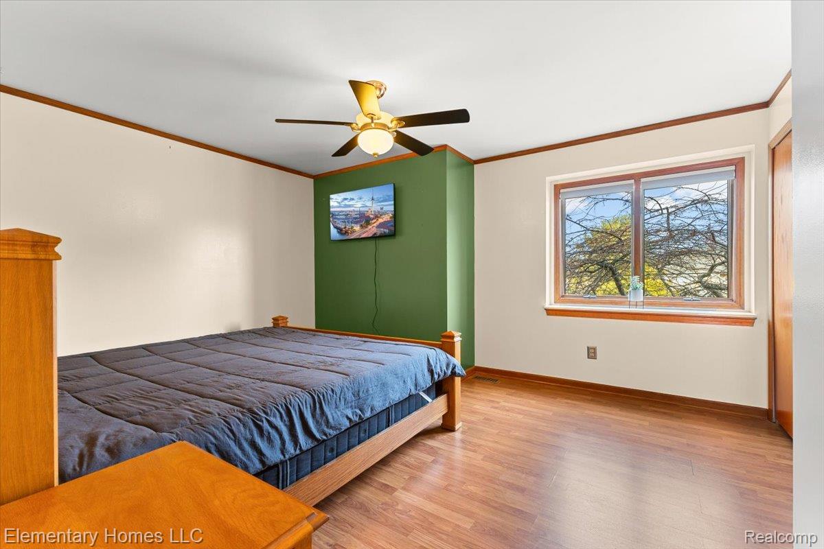 51637 Baker Road New Baltimore, MI 48047 - Photo 35 of 47 Bedroom featuring light wood-style floors, ornamental molding, and a ceiling fan