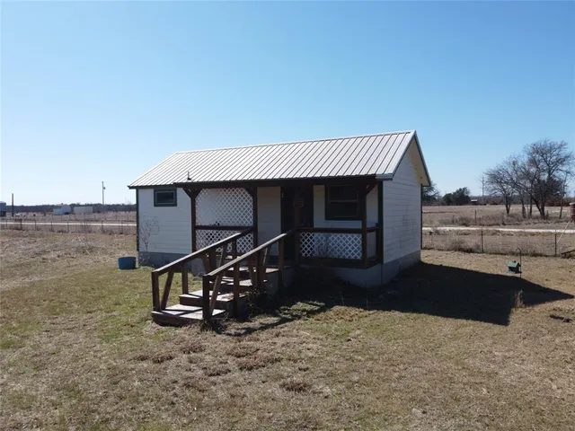 a backyard of a house with table and chairs