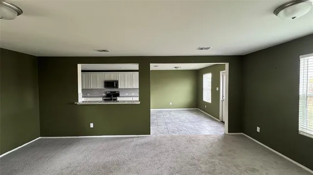 an empty room with kitchen mirror and windows