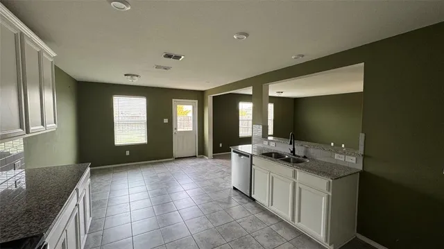 a spacious bathroom with a granite countertop sink and a mirror