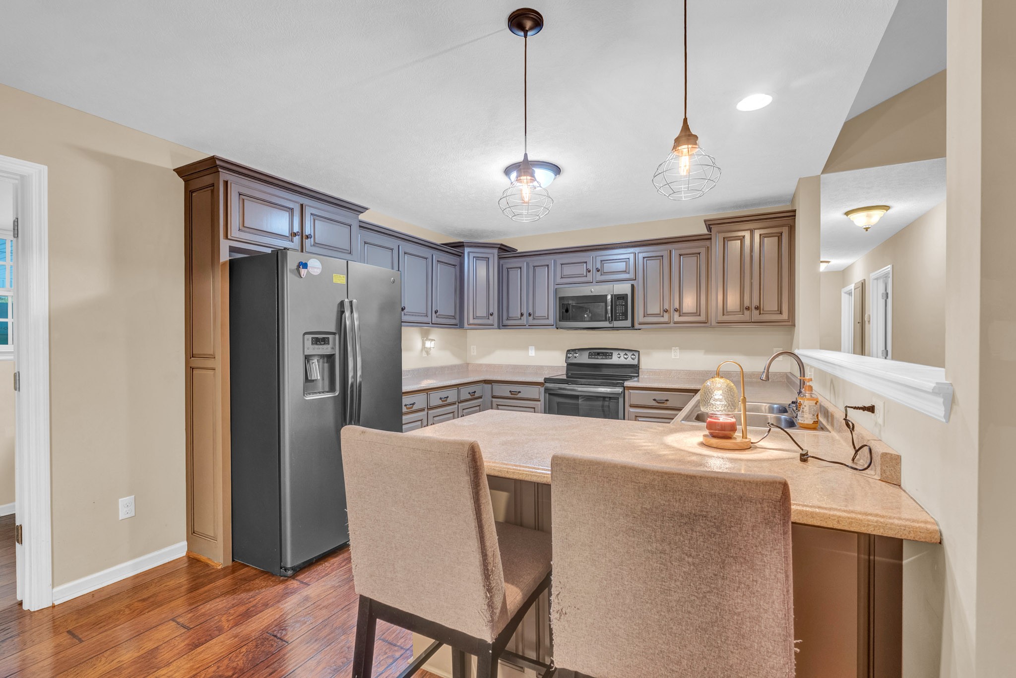 498 Bugger Ridge Road McMinnville, TN 37110 - Photo 13 of 22 a kitchen with stainless steel appliances granite countertop a refrigerator a sink dishwasher a stove a dining table and chairs with wooden floor