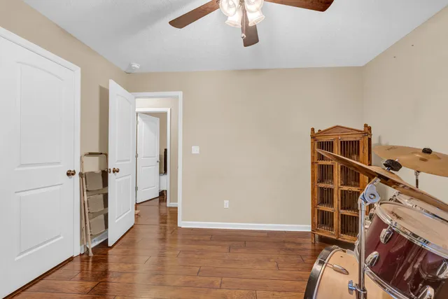 a view of an empty room with wooden floor and a fireplace